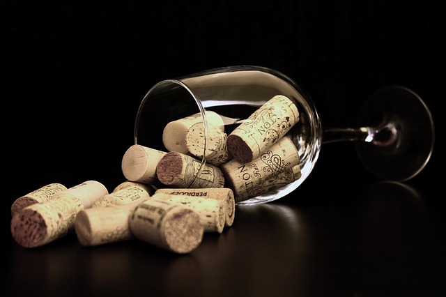 sklenka vína a korkové zátky